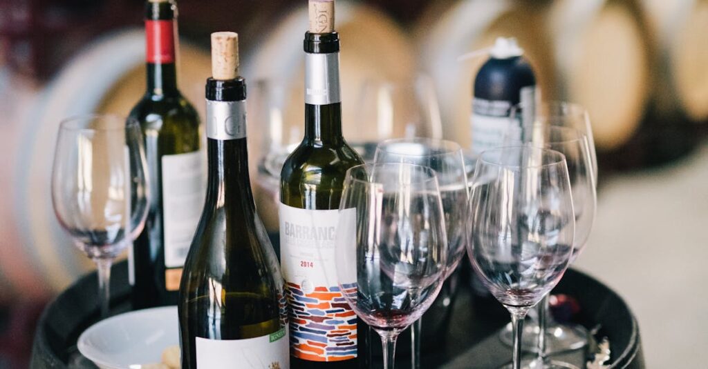 Assorted wine bottles and glasses on a barrel in a traditional winery setting.
