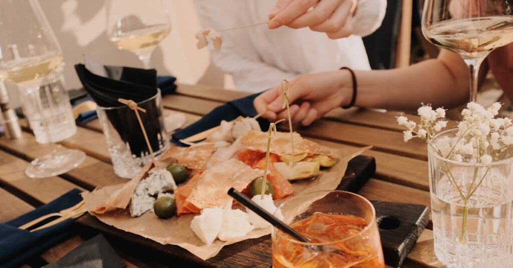 Enjoy a casual meal with wine, cheese, and snacks at an outdoor restaurant setting.